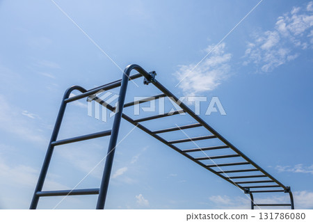 Horizontal bars in a park under a clear blue sky offer a great spot for outdoor exercise and fitness training sessions throughout the day Horizontal bars in a park under a clear blue sky offer a great spot for outdoor exercise and fitness training sessions throughout the day 131786080