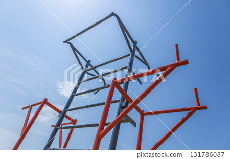 Participants are actively training on horizontal bars in a fitness park, enjoying the sunny weather and engaging in physical activity 131786087