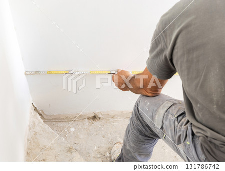 Craftman measuring a wall back view, closeup. Construction or  Home Remodeling 131786742