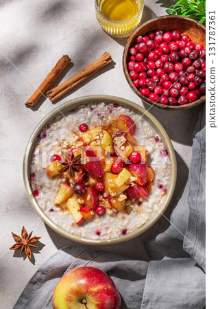 Overnight oatmeal with apples, cranberries, and cinnamon in a bowl on a light background 131787361