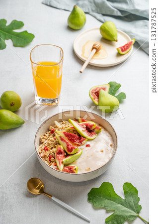 Natural yogurt with granola, figs and honey in a bowl on a light background 131787525
