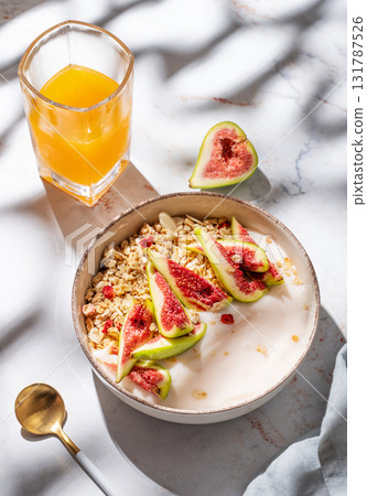Natural yogurt with granola, figs and honey in a bowl on a marble background 131787526