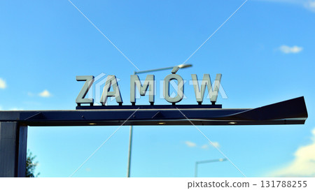 Warsaw, Poland. 11 August 2025. Urban landscape. Neon sign with the inscription:  Zamow. Warsaw, Poland. 11 August 2025. Urban landscape. Neon sign with the inscription:  Zamow. 131788255