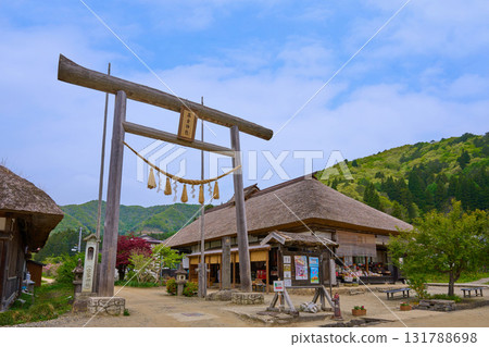 Fresh greenery in Shimogo Town, Minamiaizu County, Fukushima Prefecture. The first torii gate of Takakura Shrine in Ouchijuku, with its thatched roof. 131788698