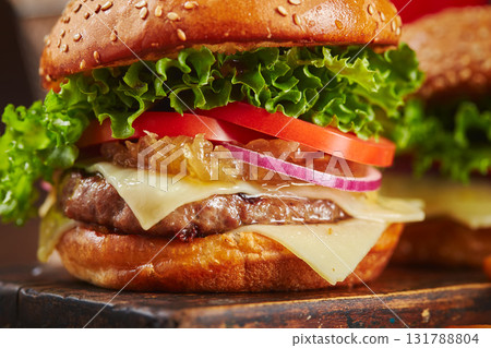Appetizing homemade burger with beef, cheese and onion marmalade close-up. Fast food concept, american food Appetizing homemade burger with beef, cheese and onion marmalade close-up. Fast food concept, american food 131788804