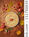 Homemade apple cake with with sour cream, red apples, Crabapples and cinnamon over wooden background, top view 131788839