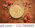Homemade apple cake with with sour cream, red apples, Crabapples and cinnamon over wooden background, top view 131788840