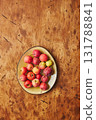 Plate with small red apples - Crabapples, on warm wooden background 131788841