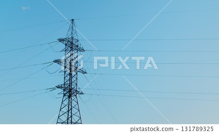 An Electricity Transmission Tower Majestically Standing Against a Stunning Blue Sky An Electricity Transmission Tower Majestically Standing Against a Stunning Blue Sky 131789325
