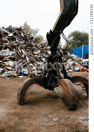Industrial Claw Lifting Scrap Metal in Junkyard Operation Industrial Claw Lifting Scrap Metal in Junkyard Operation 131789330