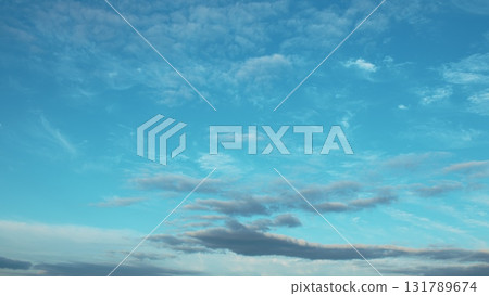 The Beautiful Blue Sky adorned with Clouds at Dusk radiates tranquility and peace The Beautiful Blue Sky adorned with Clouds at Dusk radiates tranquility and peace 131789674