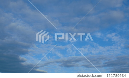 Beautiful, Fluffy Clouds Floating Gracefully Over a Clear, Expansive Blue Sky Above Us 131789684