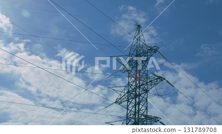 An Electricity Transmission Tower stands out against a vibrant blue sky, symbolizing connectivity An Electricity Transmission Tower stands out against a vibrant blue sky, symbolizing connectivity 131789708