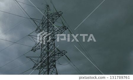 A Dramatic High Voltage Power Line Silhouetted Against the Foreboding Dark Sky Background 131789761