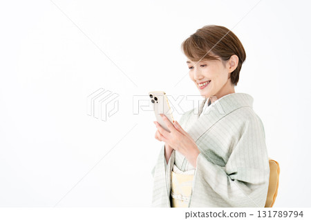一位身穿和服、手持智慧型手機的女士 131789794