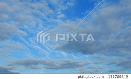 A Bright Blue Sky Adorned with Fluffy Clouds Creates a Serene Peaceful Atmosphere 131789849