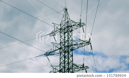 High Voltage Power Lines Stretching Against a Dramatic Cloudy Sky in the Background High Voltage Power Lines Stretching Against a Dramatic Cloudy Sky in the Background 131789934