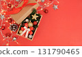 Christmas gift box overflowing with ornaments on red background 131790465
