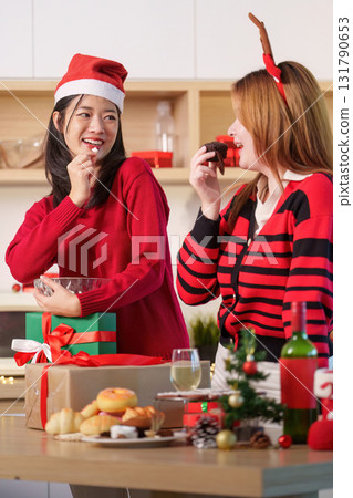 Holiday Fun. Friends enjoying Christmas treats and exchanging gifts in a cozy kitchen. Holiday Fun. Friends enjoying Christmas treats and exchanging gifts in a cozy kitchen. 131790653