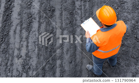 Aerial view of engineer inspecting construction site with clipboard 131790964