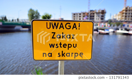 Szczecin, Poland. 16 July 2025. Urban landscape. Sign with the inscription: Uwaga! Zakaz wstepu na skarpe. Szczecin, Poland. 16 July 2025. Urban landscape. Sign with the inscription: Uwaga! Zakaz wstepu na skarpe. 131791343
