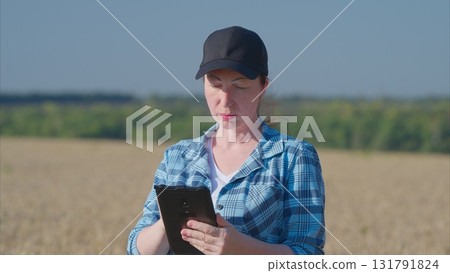 Dedicated Agriculture Professional Utilizing a Tablet While Working in the Field Environment Dedicated Agriculture Professional Utilizing a Tablet While Working in the Field Environment 131791824