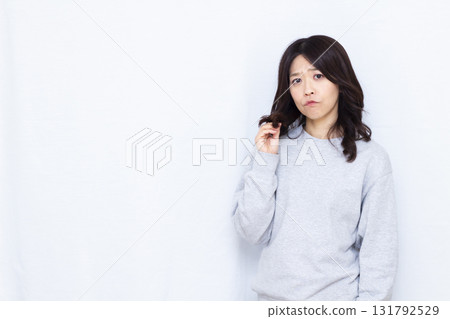 A woman who is concerned about hair damage A woman who is concerned about hair damage 131792529