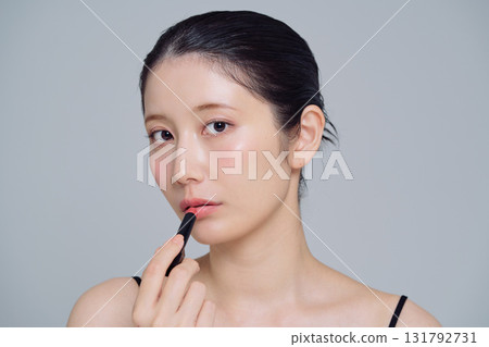 A woman applying lipstick A woman applying lipstick 131792731
