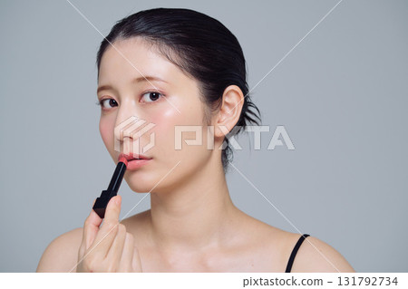 A woman applying lipstick A woman applying lipstick 131792734