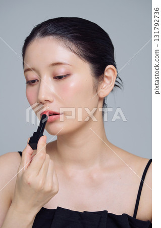 A woman applying lipstick 131792736