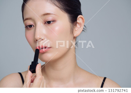 A woman applying lipstick 131792741