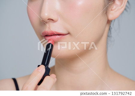A woman applying lipstick 131792742