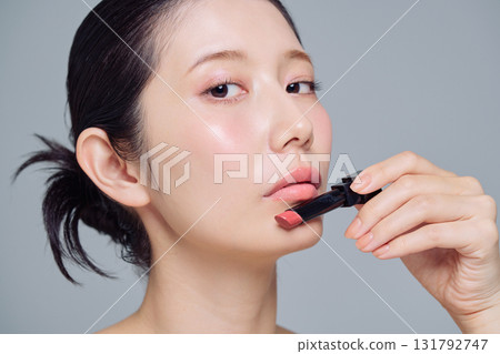 A woman applying lipstick A woman applying lipstick 131792747