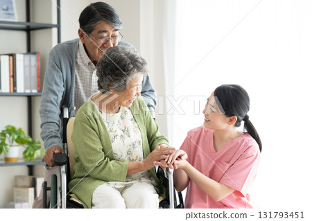 Senior couple in wheelchairs and caregivers 131793451
