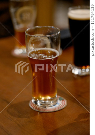 A glass of light craft beer on a wooden bar table A glass of light craft beer on a wooden bar table 131794139