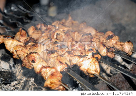 pork shashlik on skewers grilled over charcoal with smoke on the grill pork shashlik on skewers grilled over charcoal with smoke on the grill 131794184