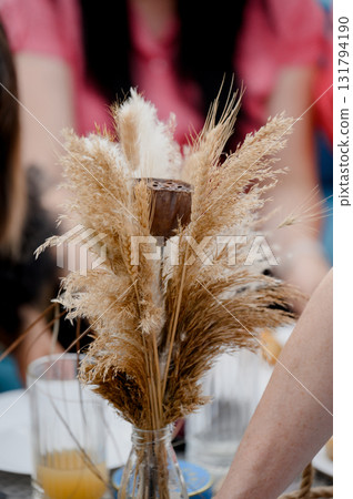 A bouquet of dried pampas grass and wheat flowers with a lotus flower in a vase 131794190