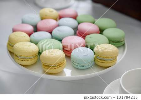Close-up of colorful French macarons on a white round stand Close-up of colorful French macarons on a white round stand 131794213