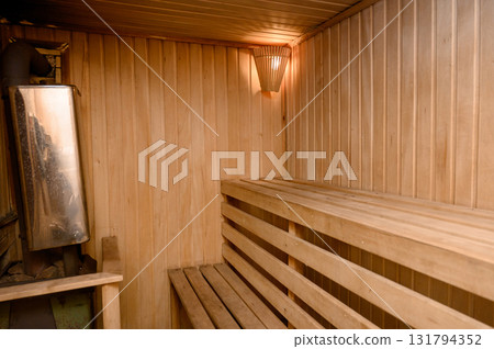 The interior of a classic steam room finished in light wood with a corner bench. 131794352