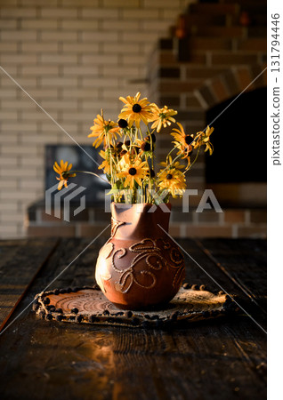 Ceramic jug with a bouquet of yellow rudbeckia on a wooden table Ceramic jug with a bouquet of yellow rudbeckia on a wooden table 131794446