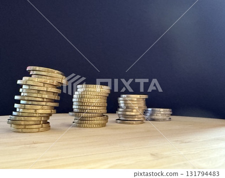 Macro photography of euro coins highlighting financial themes such as pensions, taxes, income, and losses. Money, economics, and financial literacy. Macro photography of euro coins highlighting financial themes such as pensions, taxes, income, and losses. Money, economics, and financial literacy. 131794483