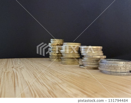 Macro photography of euro coins highlighting financial themes such as pensions, taxes, income, and losses. Money, economics, and financial literacy. 131794484