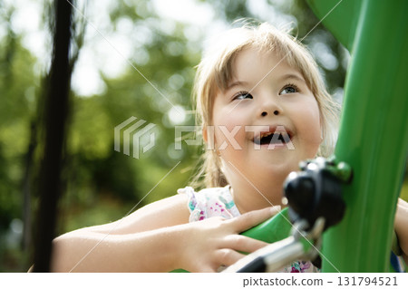 A portrait of trisomie 21 child girl outside having fun on a park 131794521