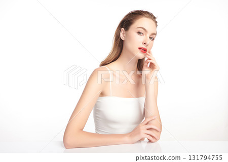 A beautiful young woman with clean, fresh skin against a white background. Skincare, facial treatment, cosmetology, beauty, and spa. An elegant portrait of an woman. 131794755