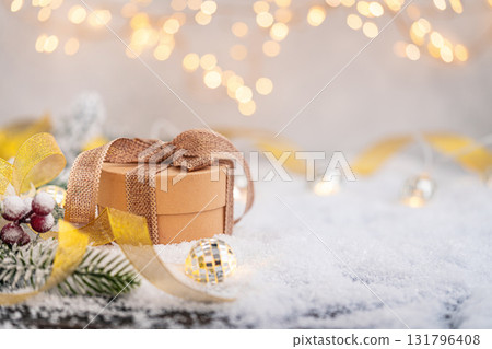 Rustic Christmas Gift Box with Burlap Ribbon on Snow Rustic Christmas Gift Box with Burlap Ribbon on Snow 131796408