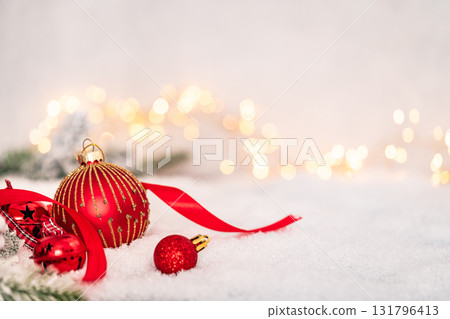 Red Christmas Ornaments on Snow with Festive Lights Red Christmas Ornaments on Snow with Festive Lights 131796413