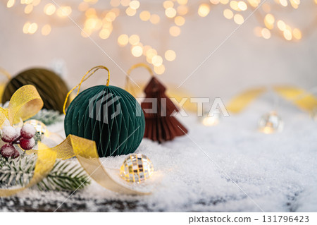 Paper Christmas Ornaments on Snow with Lights and Ribbon Paper Christmas Ornaments on Snow with Lights and Ribbon 131796423