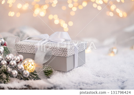 Elegant Gray Christmas Gift Box with White Ribbon on Snow Elegant Gray Christmas Gift Box with White Ribbon on Snow 131796424