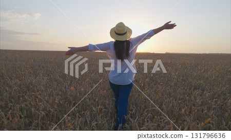 A Joyful and Relaxing Moment in a Beautiful Wheat Field Beneath a Gorgeous Sunset Sky 131796636