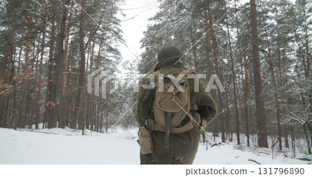 Heroes Of War. Close-up View On Re-enactor Dressed As American Infantry Soldier Going Through Forest Road Winter Day. Usa Soldier Marching By Country Road. Usa Army Soldiers Of World War Ii 131796890